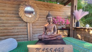 A wooden statue of a seated figure with a sign labeled "MASSAGE" in front. - Private Bungalow ZANANAS (97435)
