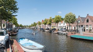Un canal con barcos, una hilera de casas y un puente.