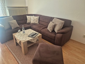 A living room with a brown sofa, a wooden coffee table, and a patterned rug. - Apartment Predigtstuhl for 2 persons, 50 sqm, balcony with unobstructed view of the mountains (Bad Reichenhall)