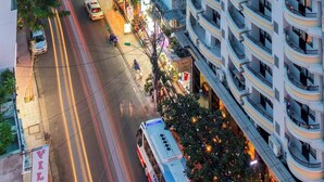 A multi-story hotel with balconies, a street view, and illuminated signs. - MIBEE Hotel (Hanoi)