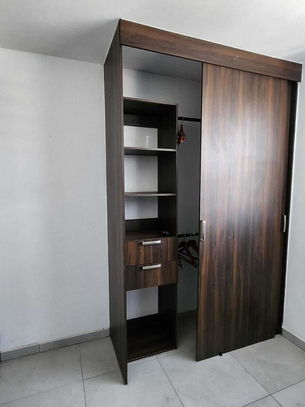 A walk-in closet with a dark wood finish, multiple shelves, and a hanging rod.