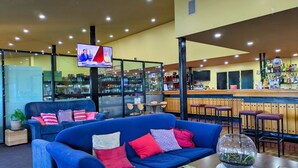 A bar area with a TV, seating, and a bar counter.