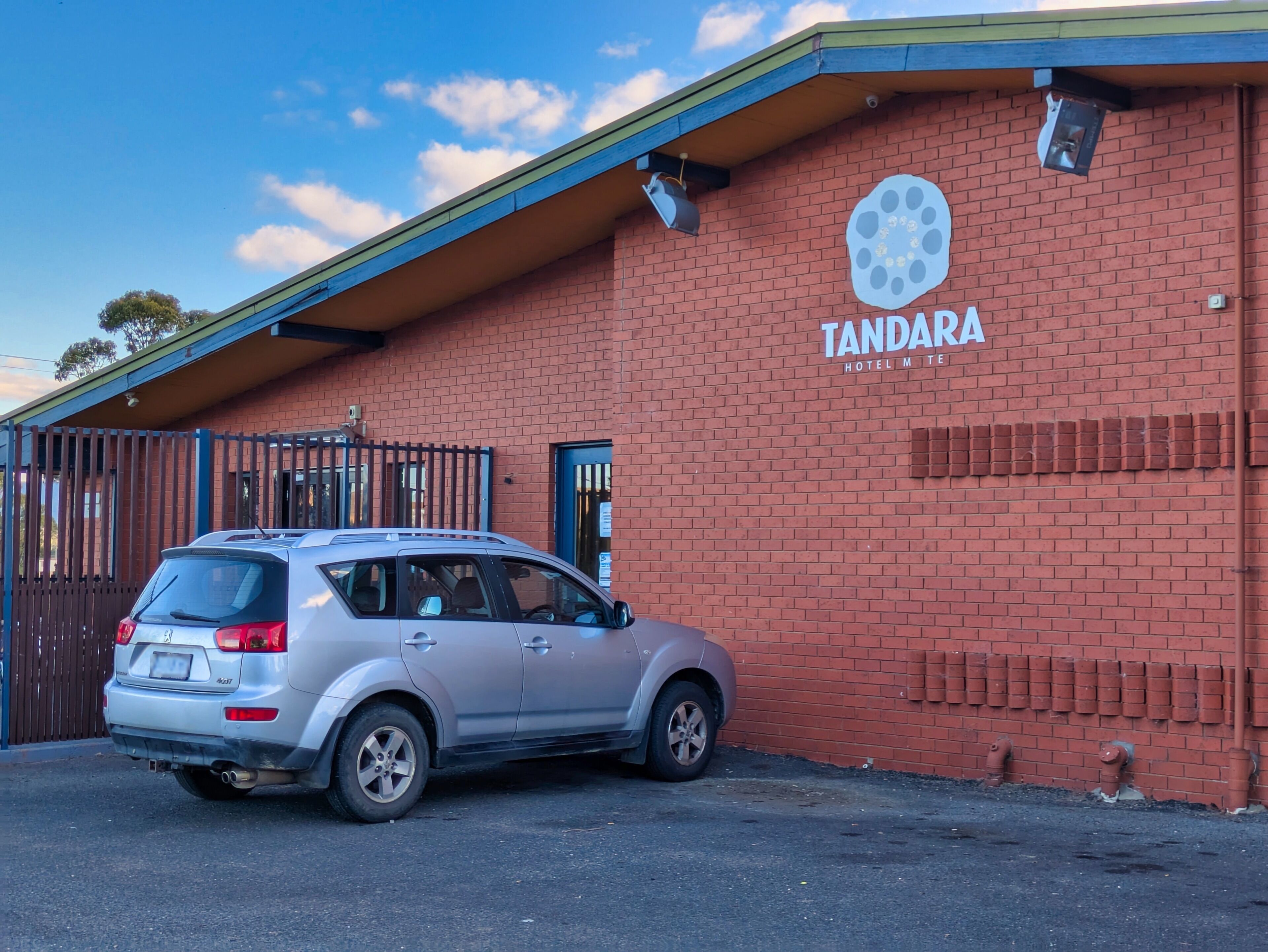 A brick building with a sign reading "TANDARA HOTEL M TERRACE".