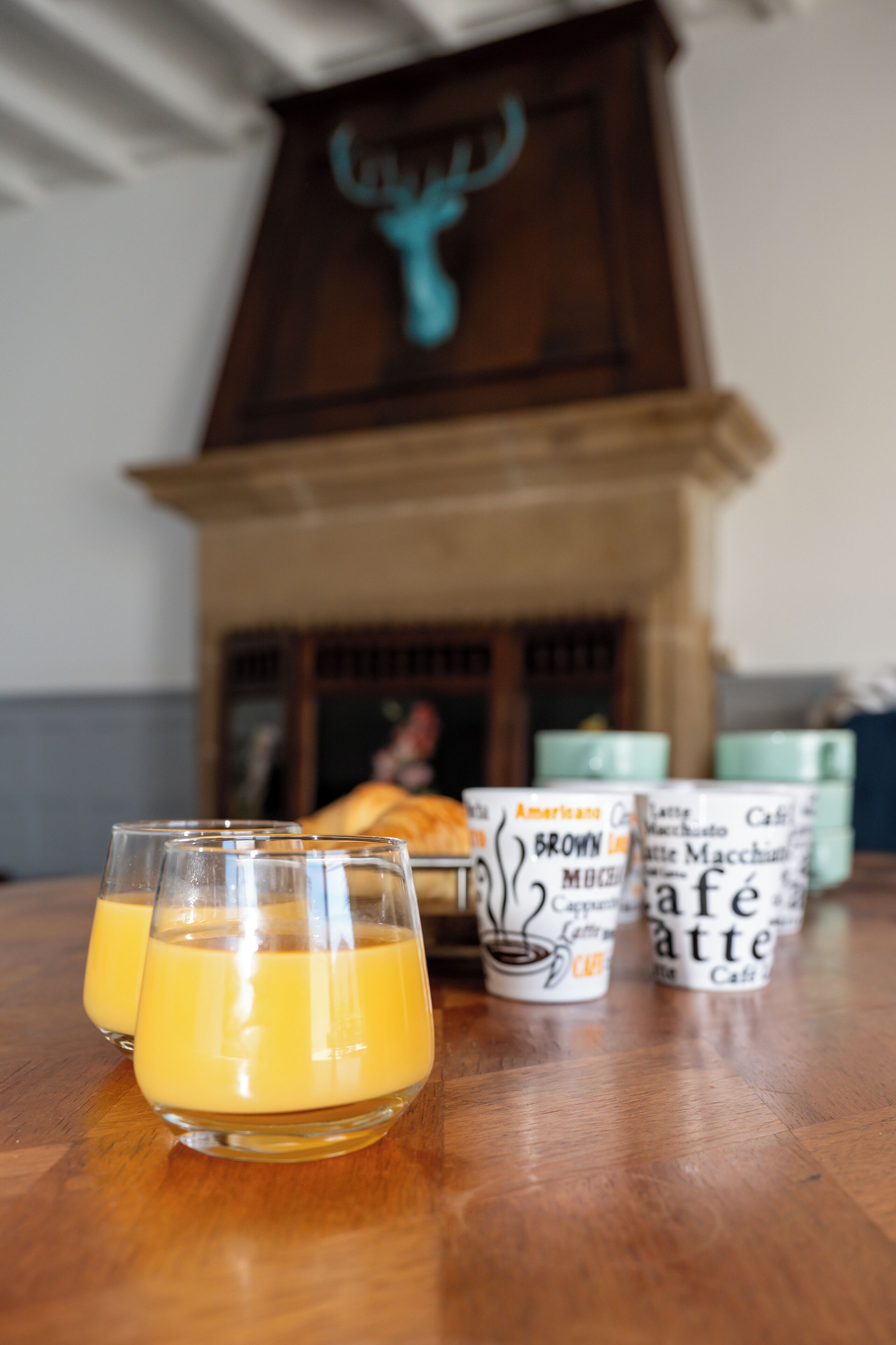 Una mesa con dos vasos de jugo de naranja y varios recipientes de café.