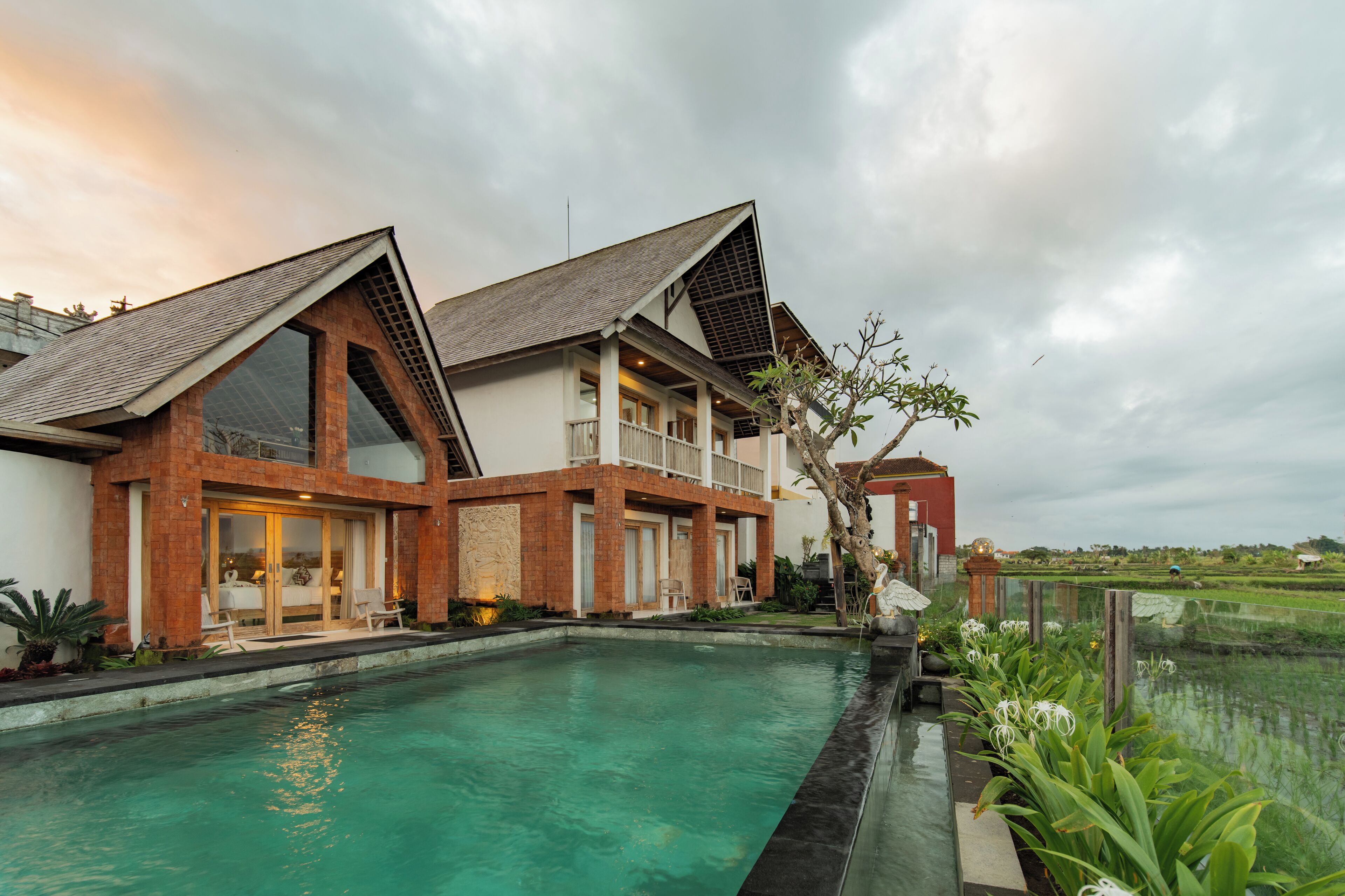 A modern house with a swimming pool, large windows, and a view of the surrounding landscape.