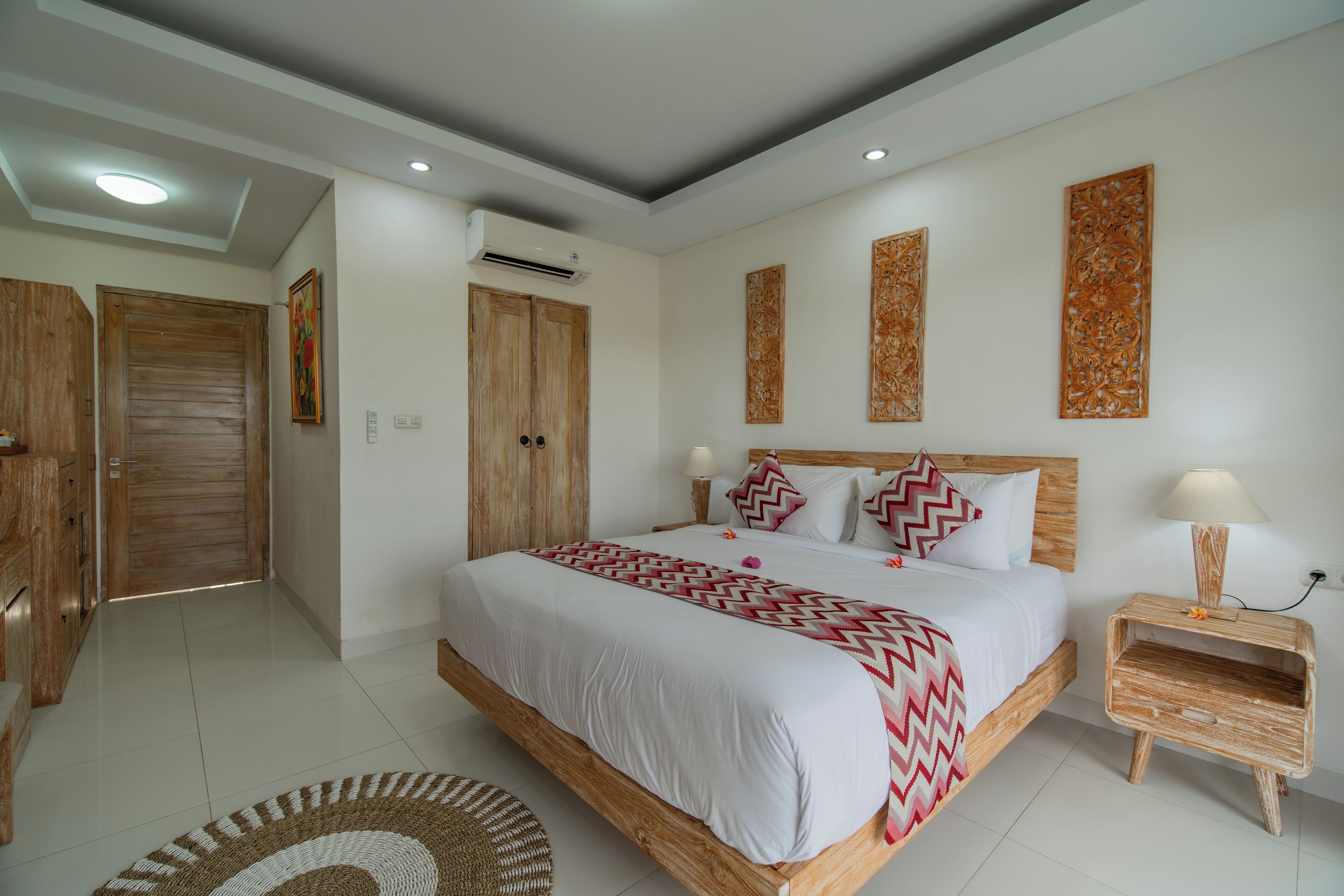 Un dormitorio moderno con una cama grande, cabecera de madera y una mesita de noche con lámpara.