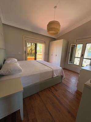 Une chambre à coucher avec un lit, une armoire et un luminaire au plafond.
