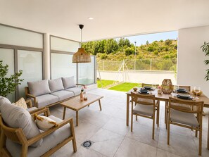 Un espace de vie moderne comprenant un canapé, une table basse et un coin repas.