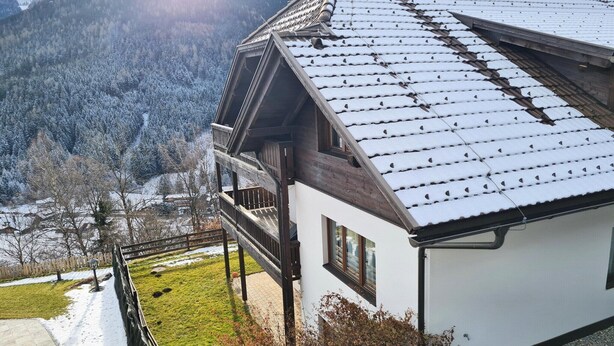 A modern house with a sloped roof, wooden balcony, and a view of a snowy forest. - Bad Gastein Fallside Apartment (Bad Kleinkirchheim)