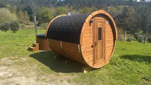 A wooden barrel-shaped structure with a door, a small porch, and a chimney. - Casa da Oliveira Pool Spa Wellness Retreat @Gerês (São Jorge)