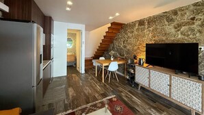 Una cocina moderna con refrigerador empotrado, armarios de madera y un comedor con mesa y sillas.