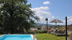 Una piscina con vistas a un pueblo y montañas al fondo.