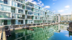 Een modern hotel met een reflecterend zwembad en glazen gevel.