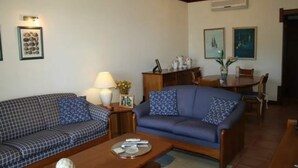 Un salon comprenant un canapé, une table basse et un coin repas avec une table et des chaises.