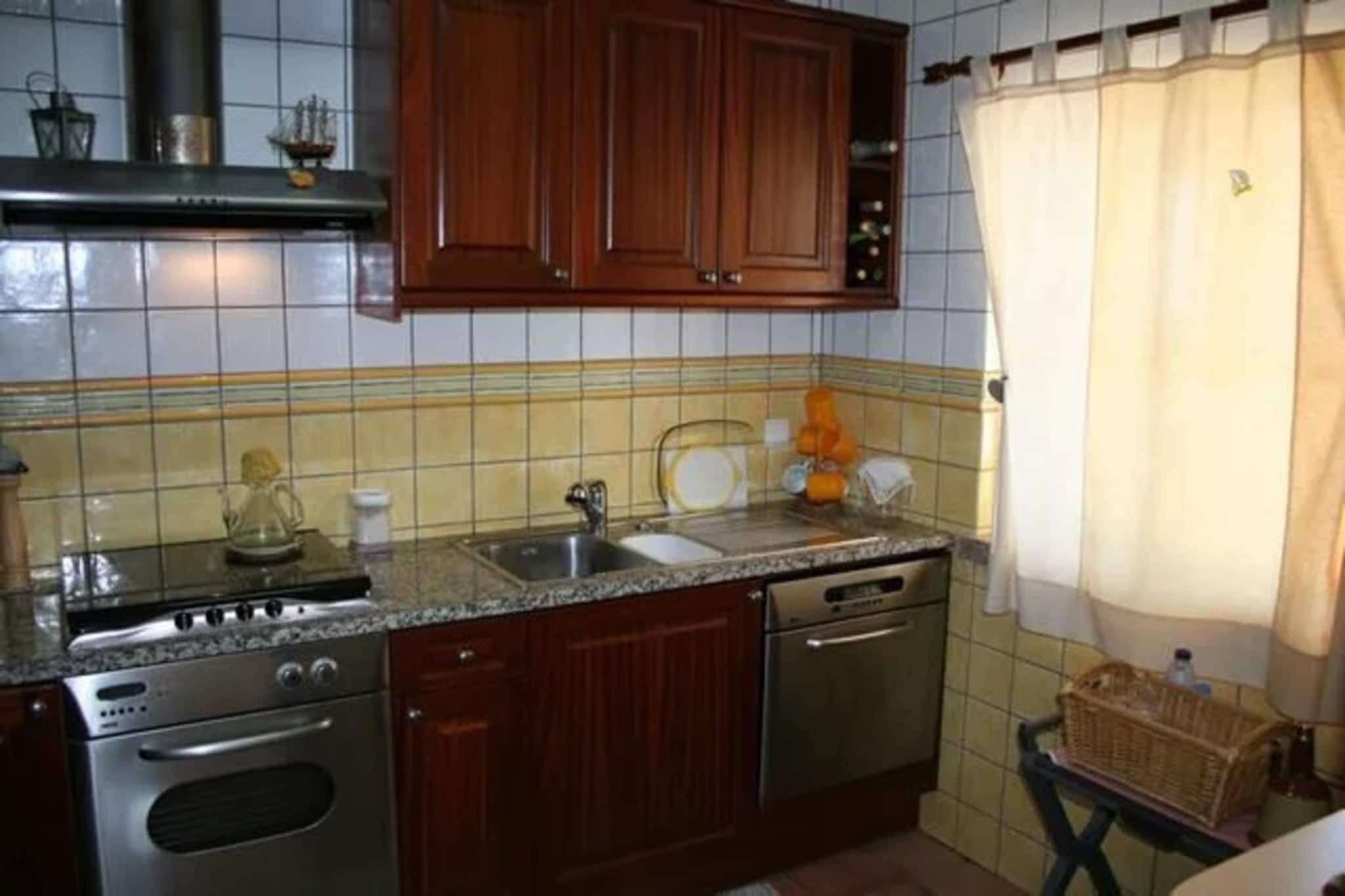 A kitchen with wooden cabinets, a stainless steel stove, and a tiled backsplash.