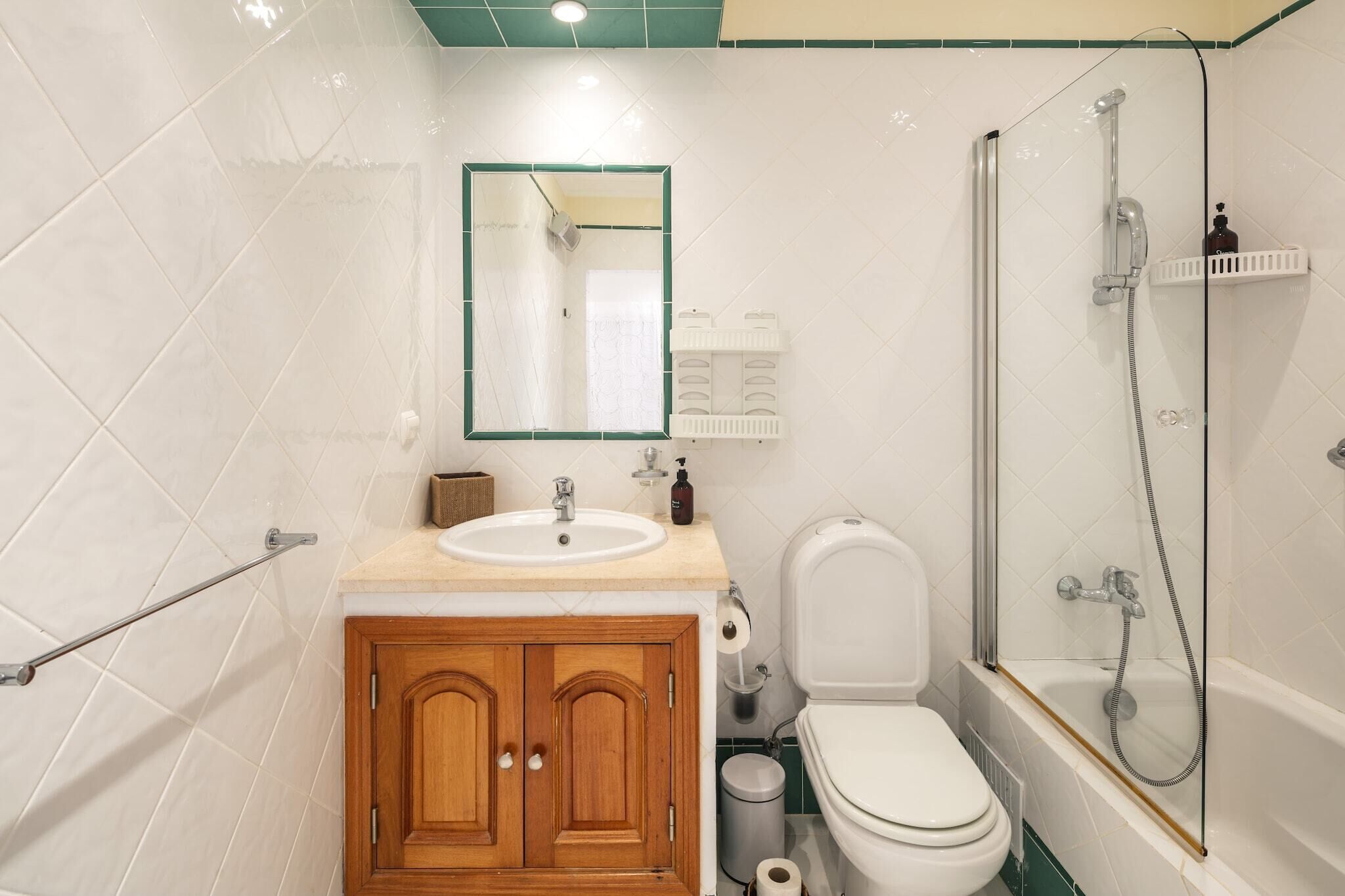 A bathroom with a toilet, sink, and shower.