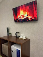 Deluxe trippelrum - utsikt mot trädgården | Värdeförvaringsskåp på rummet och arbetsyta för laptop