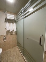 Deluxe trippelrum - utsikt mot trädgården | Badrum | Dusch, hårtork, tofflor och handdukar