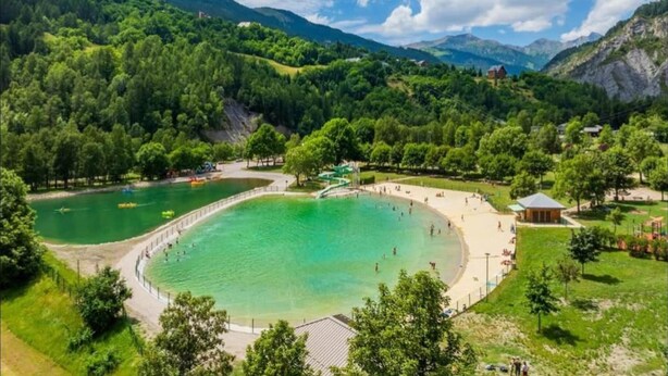 A large, circular water body surrounded by a park with walking paths and a small building. - Apartment in France with Stunning Mountain Views (Allos)