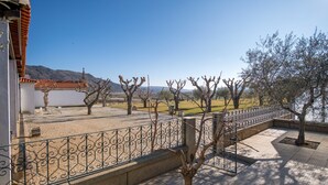Une cour dotée d’un toit en tuiles, d’un espace clos et offrant une vue sur un paysage montagneux.