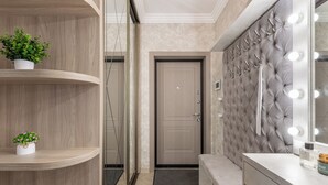 A modern bathroom with a vanity, a mirror with lights, and a door with a mirror above it. - 3-room apt with view of National Library (Minsk)
