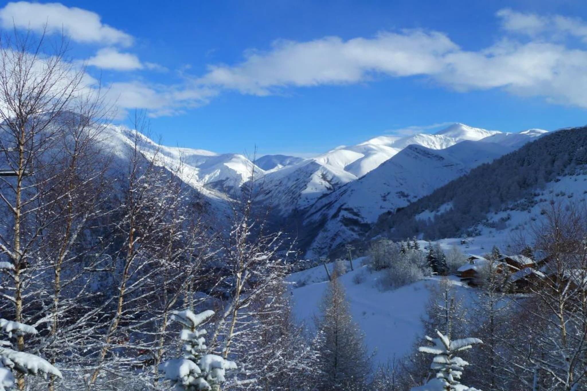 A mountainous landscape with snow-covered peaks and a clear sky.