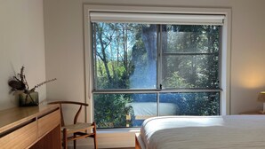 A bedroom with a large window, a bed, a chair, a desk, and a lamp. - Rainforest retreat near Canyon Lookout & trails, mins to Springbrook wonders (Springbrook)