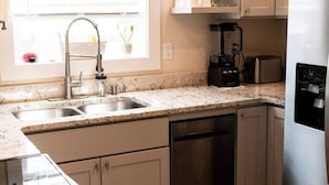A kitchen with a stainless steel refrigerator, a coffee maker, and a microwave.