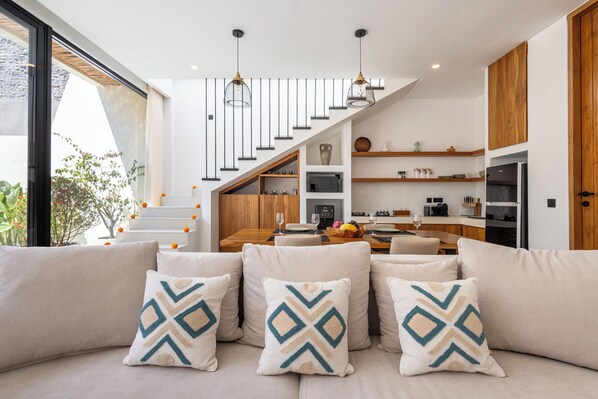 Een modern interieur met een trap, een eethoek en een keuken.