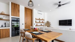 Une cuisine moderne avec une table à manger en bois, des chaises et un four encastré.