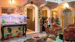 Una habitación con un acuario grande, muebles de mimbre y detalles arquitectónicos decorativos.