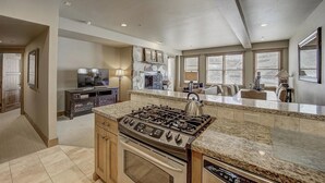 A spacious kitchen with granite countertops, a built-in stove, and a large window overlooking the living area. - 7 Condos, Ski-in/Ski-Out + Hot Tubs | Sleeps 30 | Mont Cervin by AvantStay (Park City)