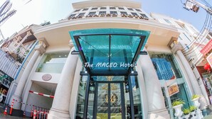 The entrance of The MCEO Hotel with a glass facade and a sign above the doors. - The MACEO Hotel (Nong Khai)