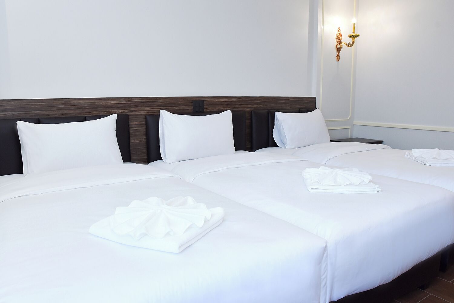 Ein Hotelzimmer mit einem großen Bett, zwei Nachttischen und einer wandmontierten Leuchte.