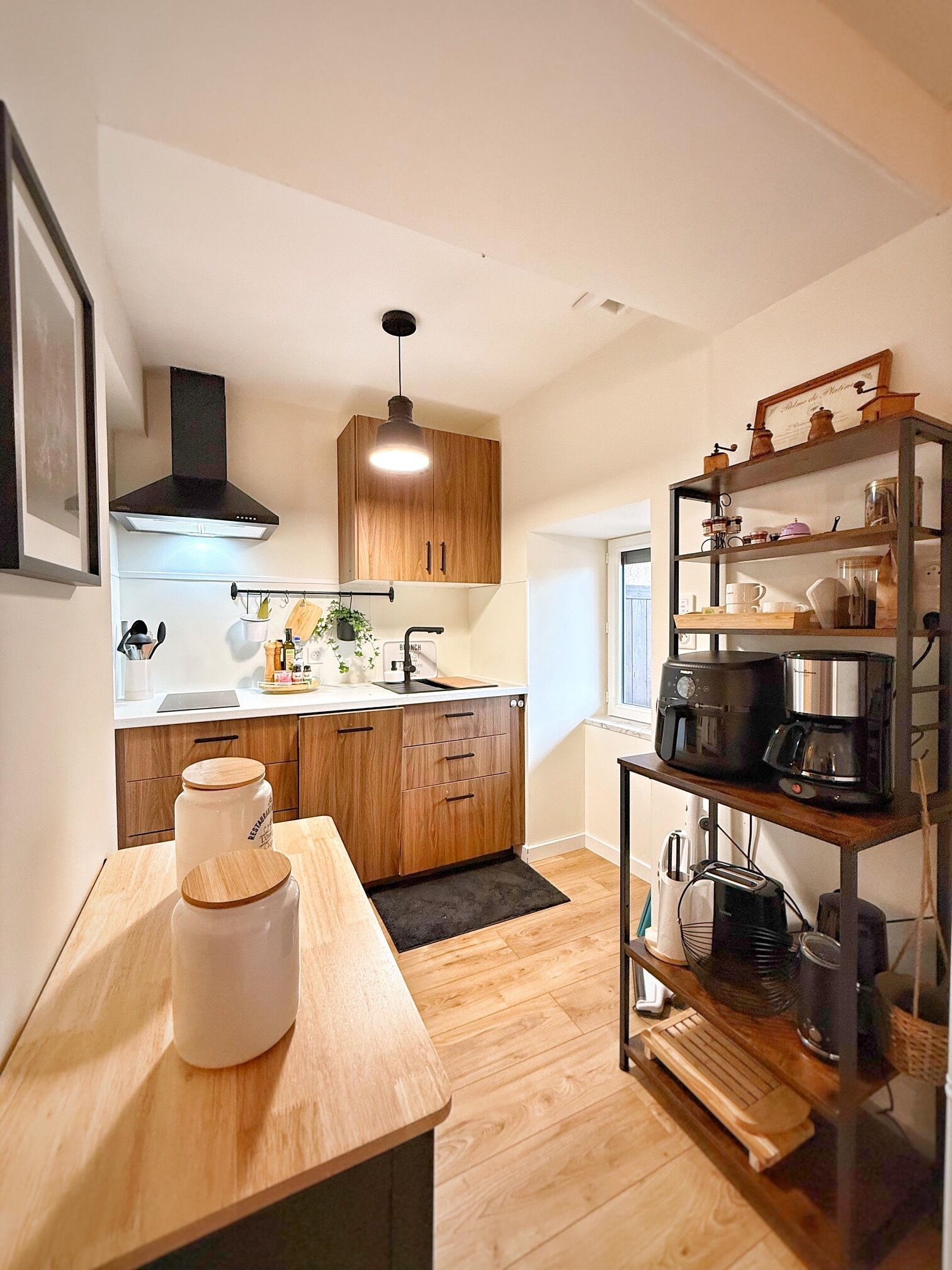 Una cucina moderna con mobili in legno, forno integrato e macchina da caffè su un ripiano.