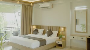 Ein modernes Hotelzimmer mit einem großen Bett, Nachttischen, einem Spiegel und einem Balkon mit Blick.