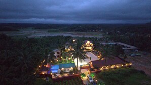 Ein Resort mit mehreren Gebäuden, einem Pool und einem gut beleuchteten Eingang.