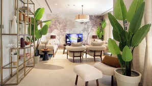 A modern living room with a sofa set, a coffee table, and a TV displaying 'Silk Valley Holiday Inn'. - Silk Valley - 4B  private beach access (Ghantoot)