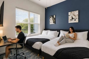A hotel room with two beds, a desk, and a window with blinds. - CPCC Area Escape | Pool Gym Parking Balcony (Charlotte)