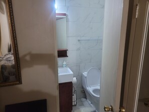 Ein Badezimmer mit Toilette, Waschbecken und Spiegel.
