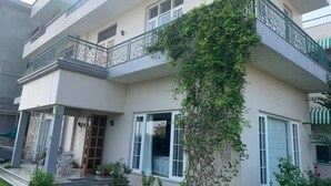 A two-story building with a balcony, a door, and a window. - IT City Homestay-Secure & Comfortable Stay in Mohali (Sahibzada Ajit Singh Nagar)