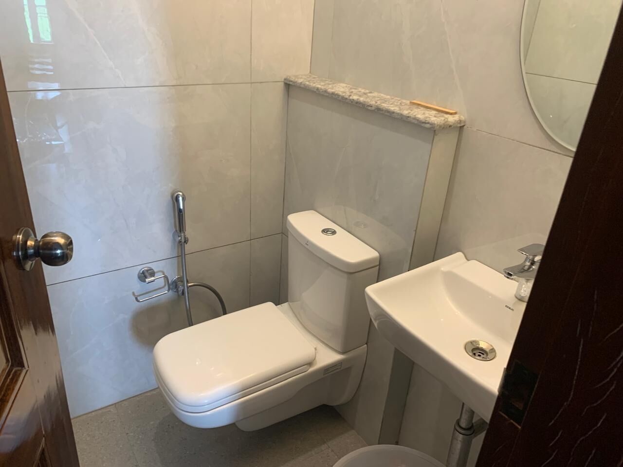 A compact bathroom with a toilet, sink, and shower.
