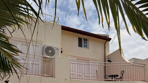 A two-story building with a balcony, outdoor seating, and a swimming pool. - Villa Ray: 3BR Gated Gem with Private Pool, Steps to Beach (Gros Islet)
