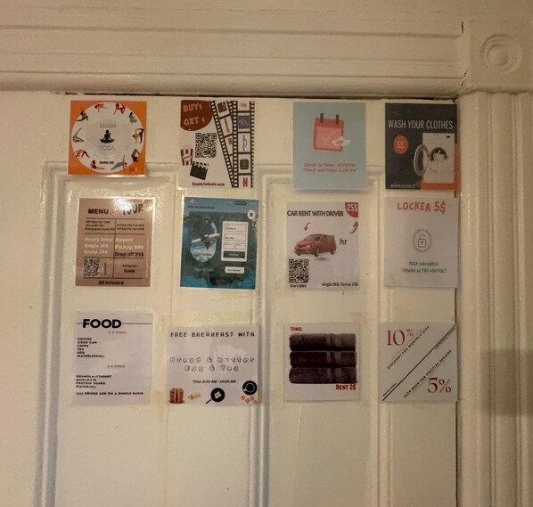 A wall with various promotional flyers and notices, including a yoga course flyer, a car rental ad, and a free breakfast offer.