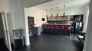 Eine moderne Küche mit Barbereich, inklusive Weinkühler, großem Kühlschrank und Barhocker.
