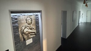 Ein Flur mit einer Wandskulptur und einer Tür.