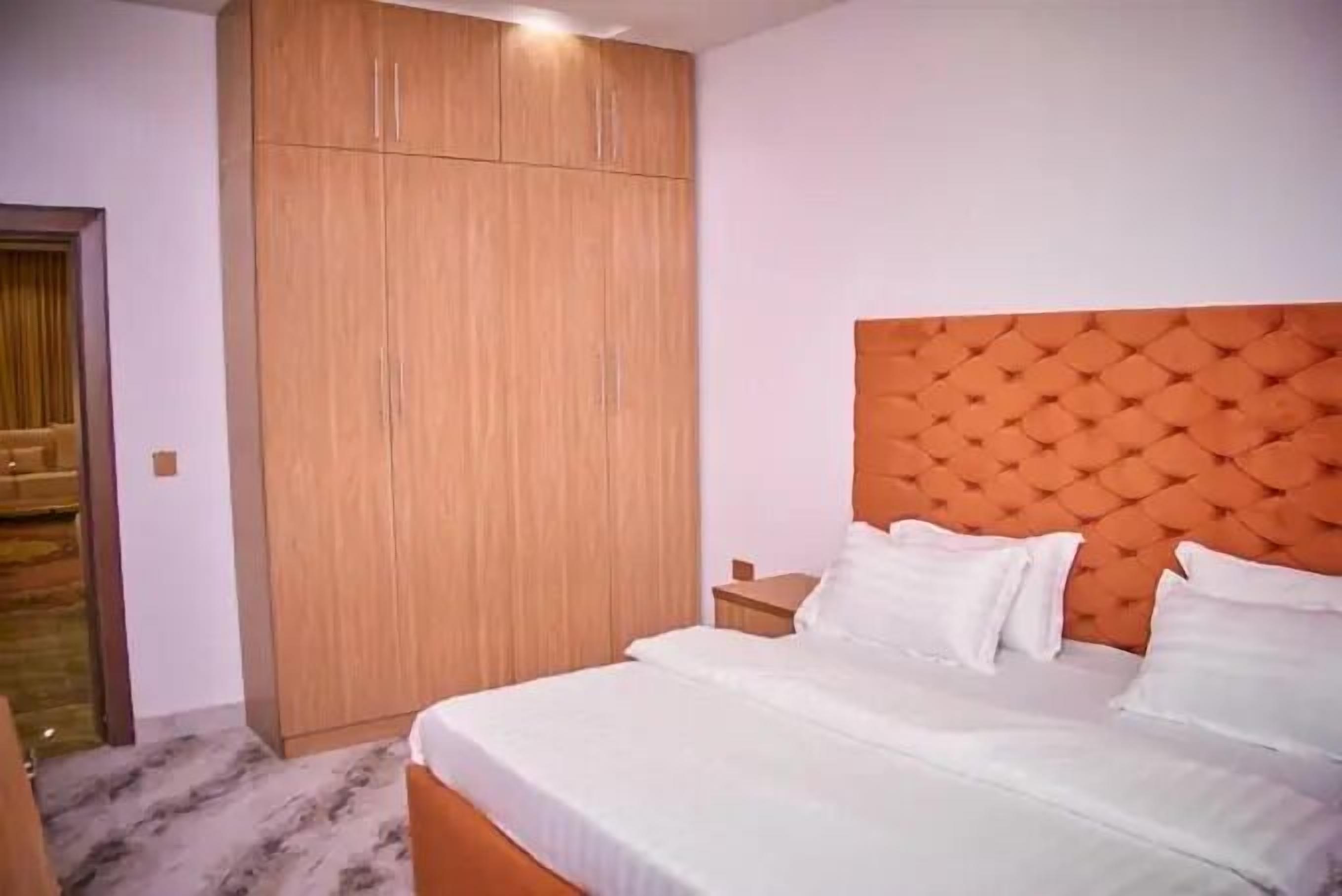 Une chambre à coucher avec un lit, une armoire et une table de chevet.