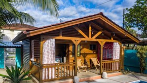 A wooden cabin with a covered porch, a pool, and a tropical garden. - Boutique Tropical Paradise Large Groups Pool & A/C (Playa Herradura)
