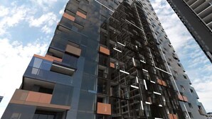 A high-rise building with a modern architectural design, featuring multiple balconies and a complex facade structure.