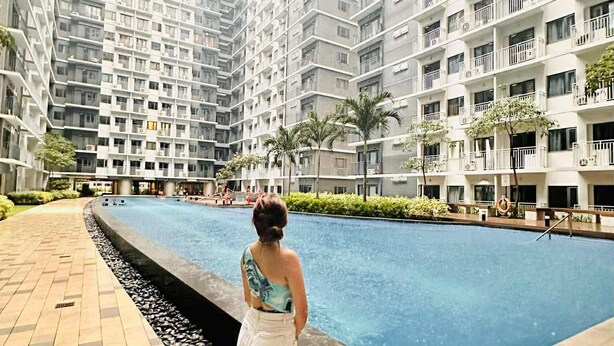 A residential building with multiple balconies and a swimming pool area. - CONDO NEXT DOOR PH (Pasay)